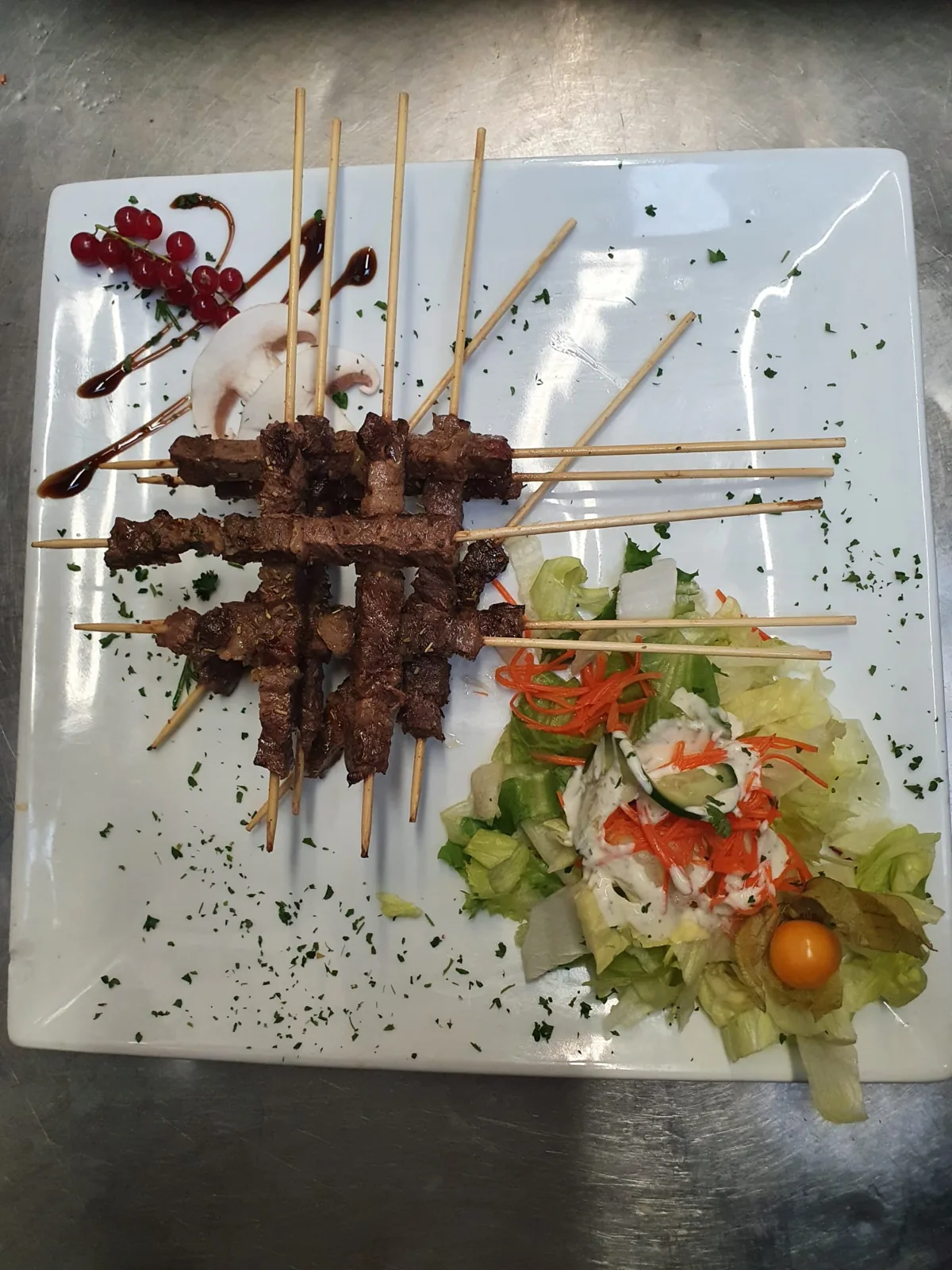 Brochettes de viande, salade et groseilles