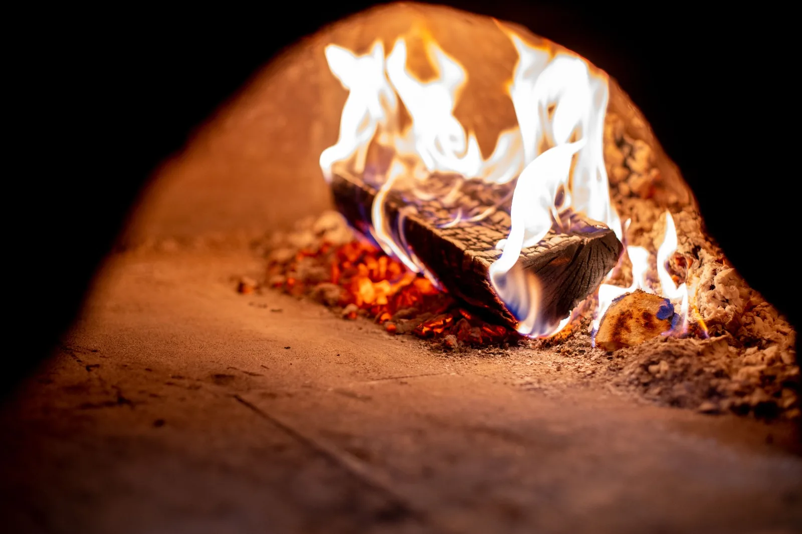 Bûche en flammes dans le four à pizza