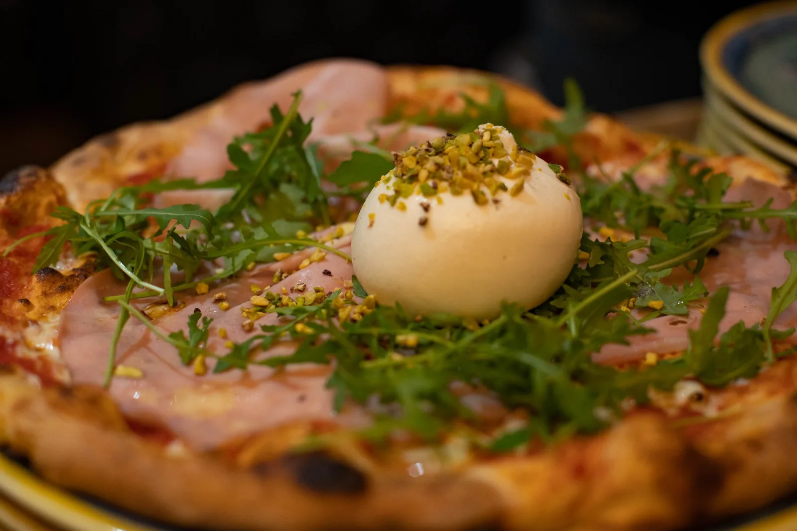 Pizza au jambon, burrata, roquette et pistaches