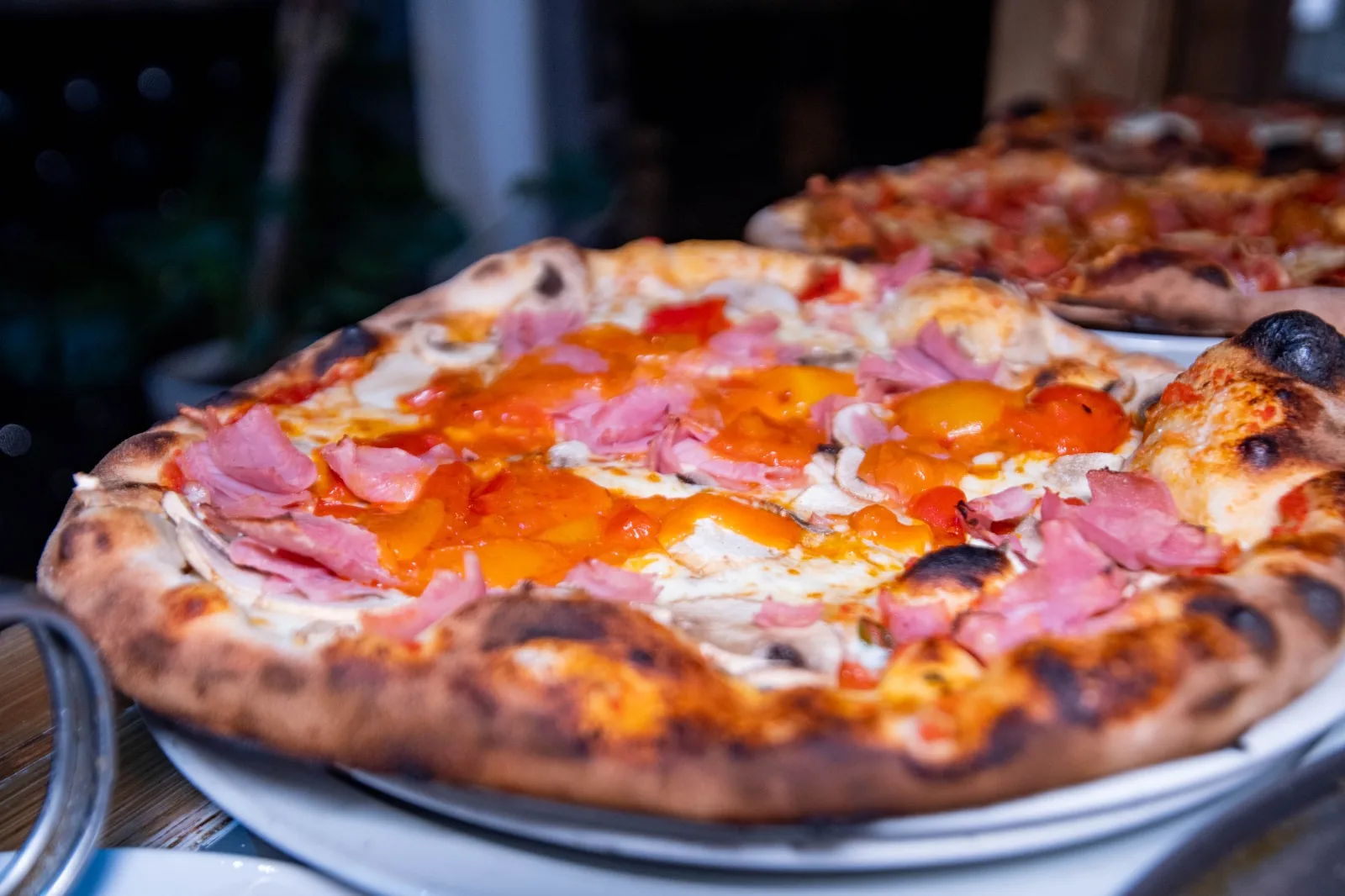 Pizza au jambon et aux poivrons sortie du four à bois
